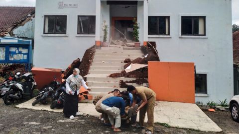 Cianjur'daki belediye görevlileri, depremin ardından yaralanan bir meslektaşını tahliye ediyor.