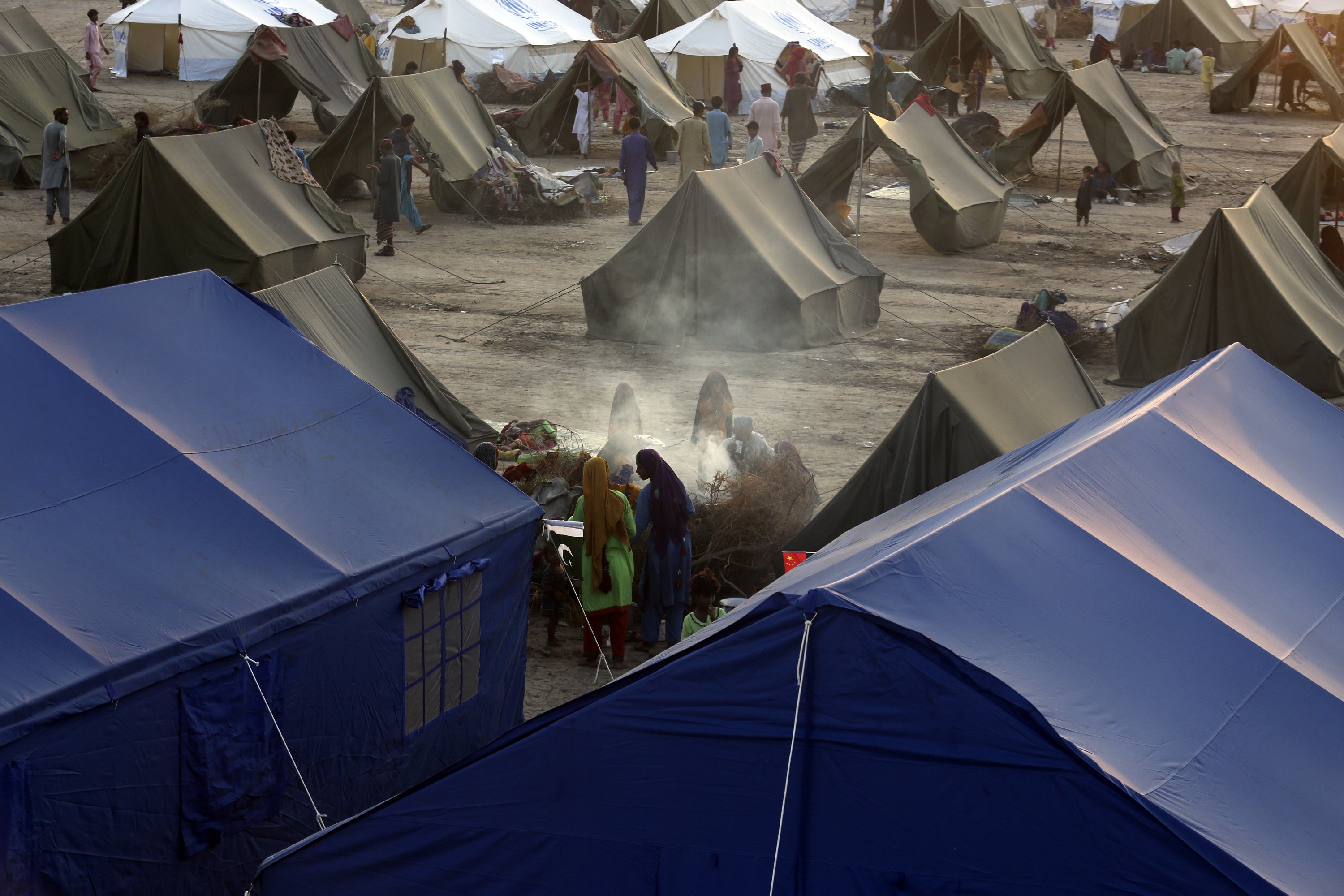 Muson yağmurlarından kaynaklanan yoğun sel mağdurları, UNHCR tarafından düzenlenen geçici bir çadır kampında çay hazırlarken sığınıyor, Sukkur, Pakistan, 10 Eylül 2022. (AP Fotoğrafı)