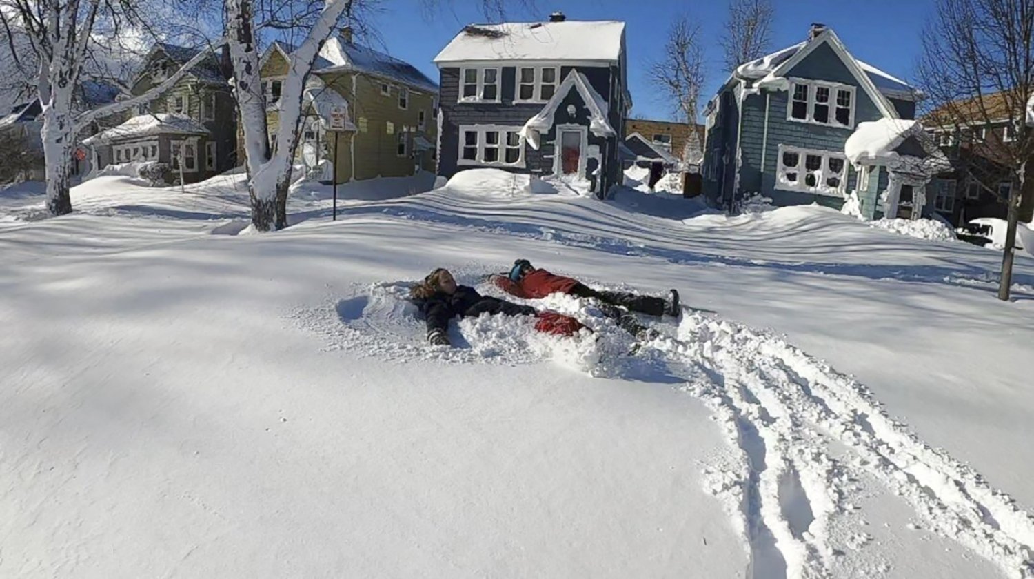 Buffalo, New York, ABD'de kar fırtınasından sonra iki kişi kardan melek yapıyor, 25 Aralık 2022. (AP Fotoğrafı)