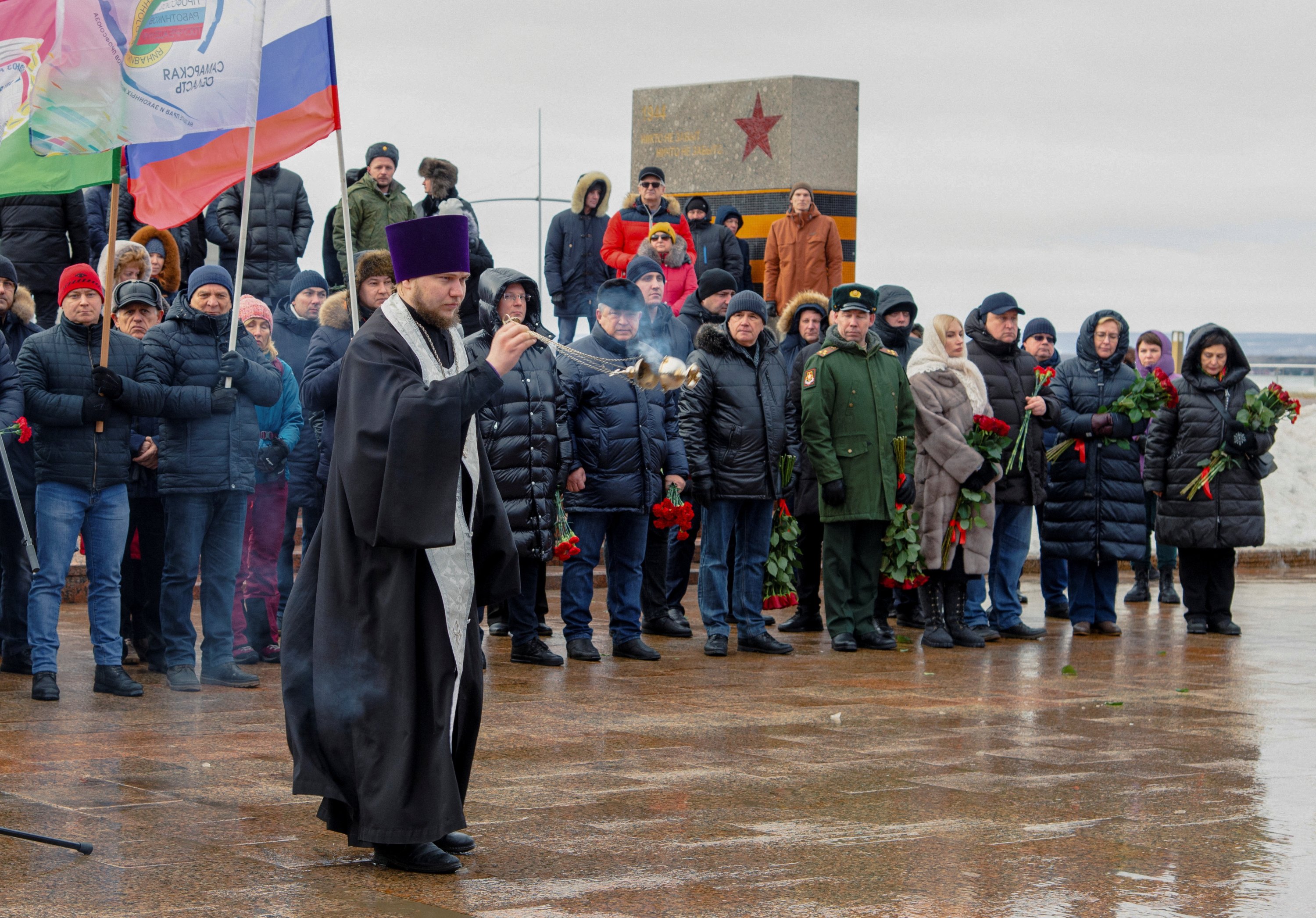 Bir rahip, Ukrayna saldırısında öldürülen 60'tan fazla Rus askerinin anısına Ebedi Alev anıtında düzenlenen törende ayin düzenliyor, Samara, Rusya, 3 Ocak 2023. (AFP Fotoğrafı)