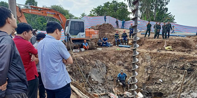 Kurtarma görevlileri, 2 Ocak 2023'te Vietnam'ın Dong Thap Eyaletindeki bir köprü şantiyesinde 35 metre derinliğindeki bir kuyuda mahsur kaldığına inanılan 10 yaşındaki bir çocuğun bulunduğu bölgeye bakıyor. 