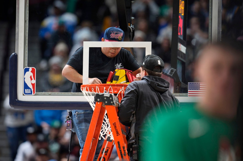 İşçiler bir Nuggets-Celtics maçında kırık bir jantı tamir etmeye çalışıyor