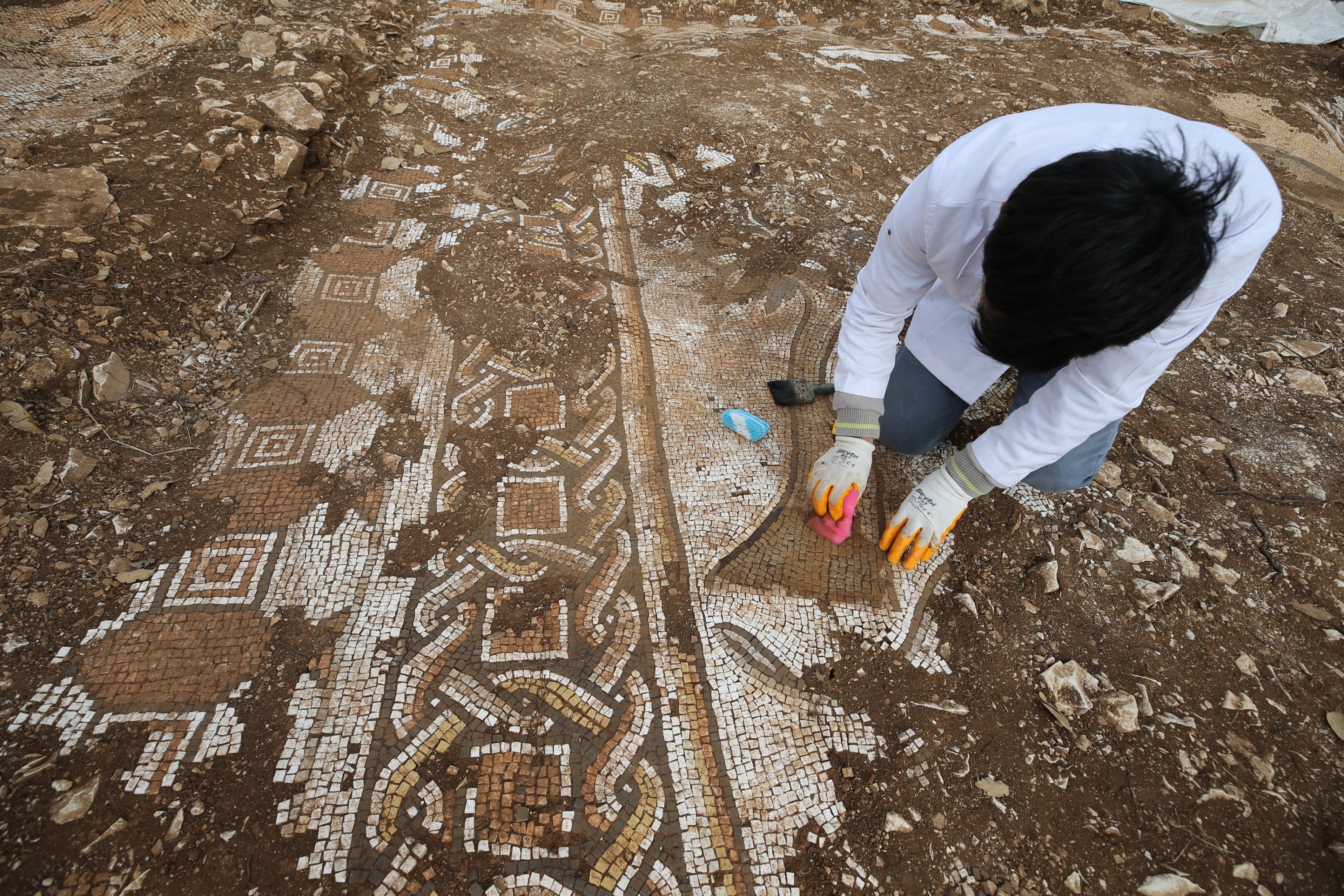 Bir arkeolog, Mardin'in Kızıltepe ilçesinde bulunan Roma dönemine ait mozaikleri fırçalıyor, 11 Aralık 2023. (AA Fotoğraf)