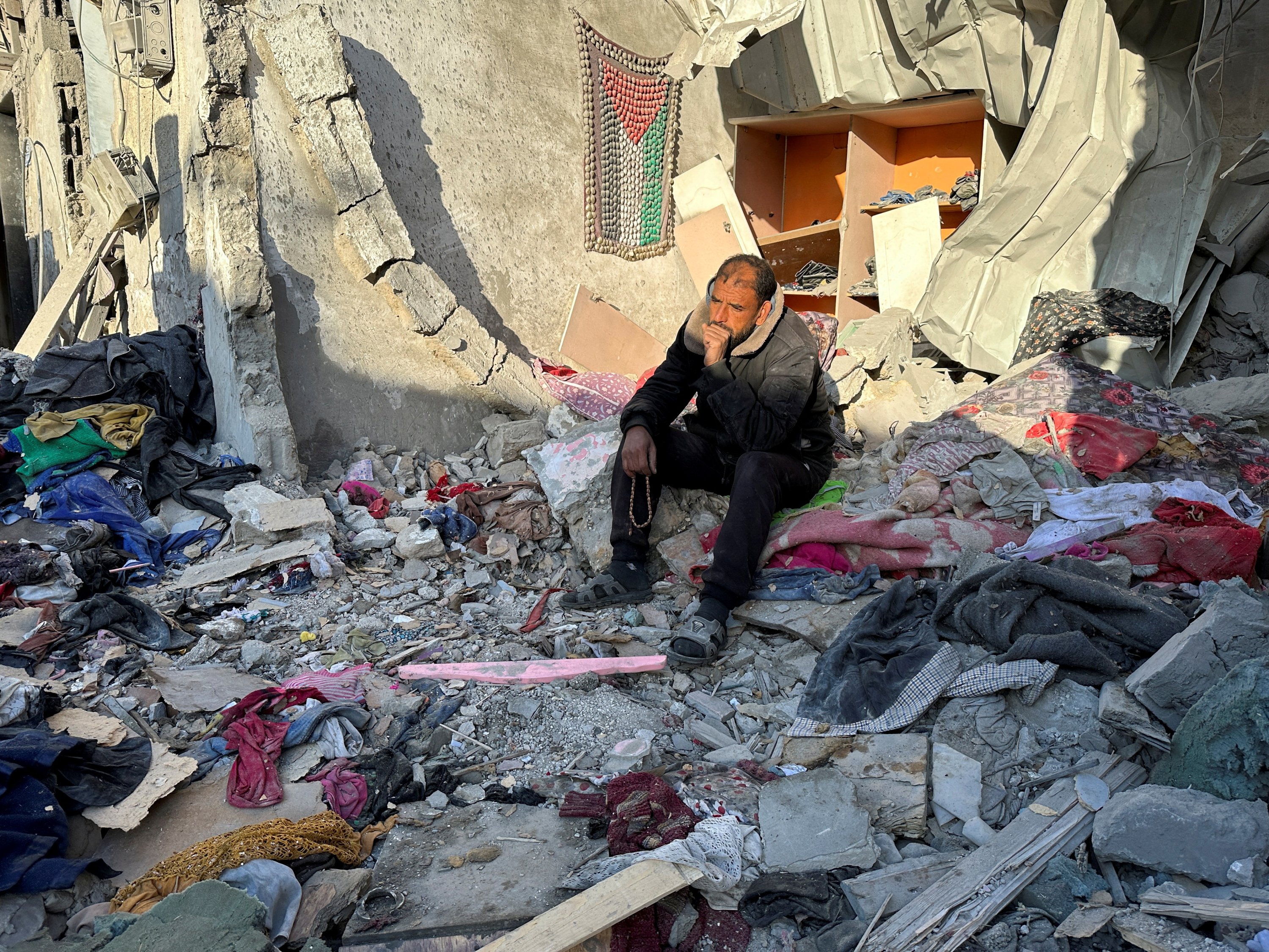 Bir adam, İsrail'in Gazze Şeridi'nin güneyindeki Refah'taki bir eve düzenlediği saldırıyı izliyor, Filistin, 18 Ocak 2024. (Reuters Fotoğrafı)