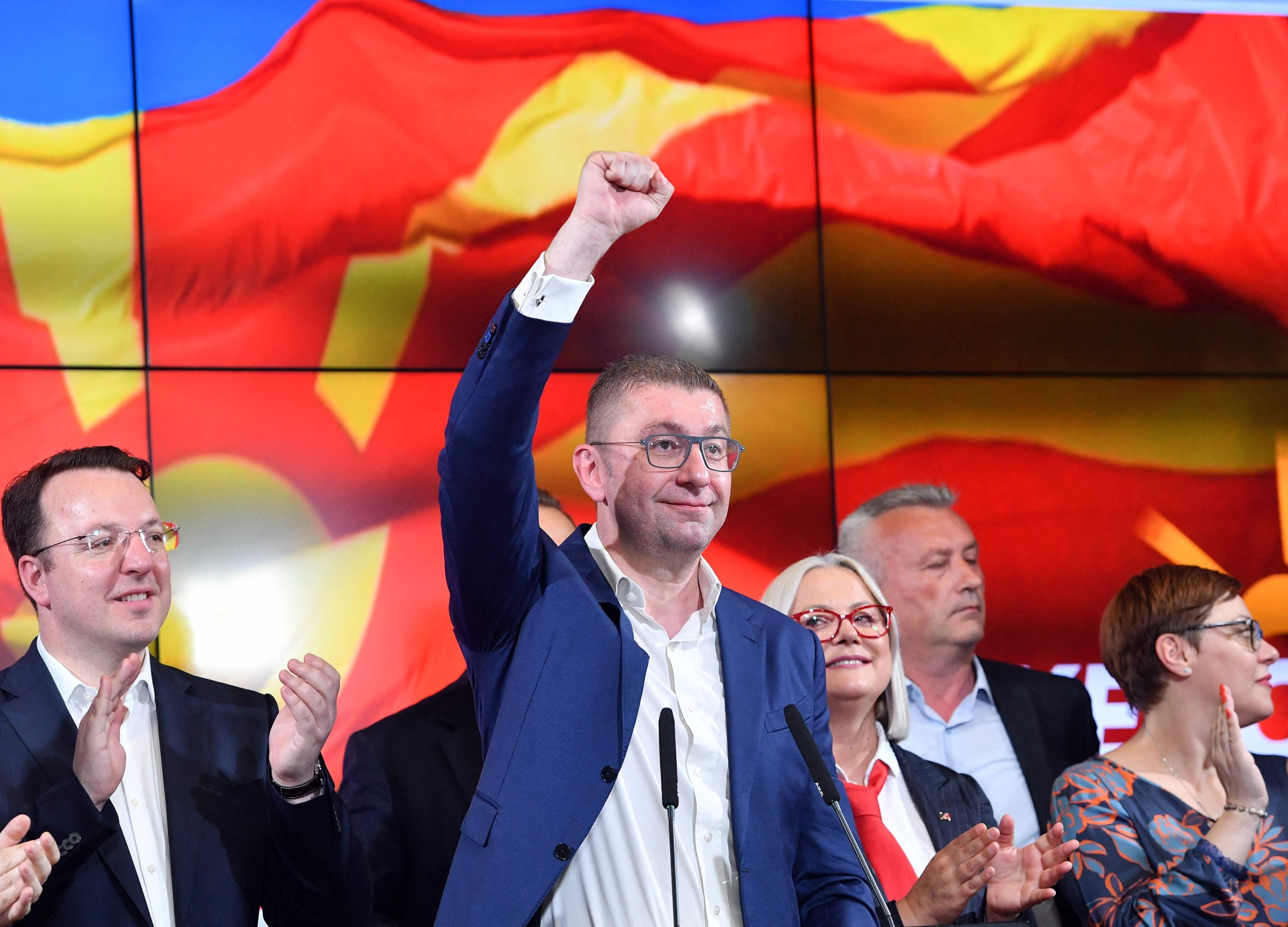 Kuzey Makedonya'nın VMRO-DPMNE partisi lideri Hristijan Mickoski (C), 8 Mayıs 2024'te Kuzey Makedonya'nın Üsküp kentinde düzenlenen parlamento ve cumhurbaşkanlığı seçimleri sırasında düzenlediği basın toplantısında el sallıyor. (AFP Fotoğrafı)